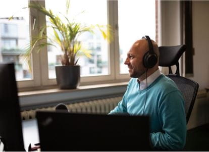 Jan Christoph Ebersbach von identinet ist mit Kopfhörern am Computer